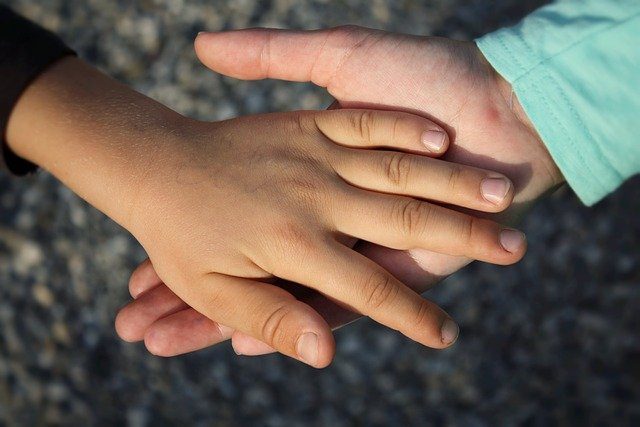 A parent holding child's hand